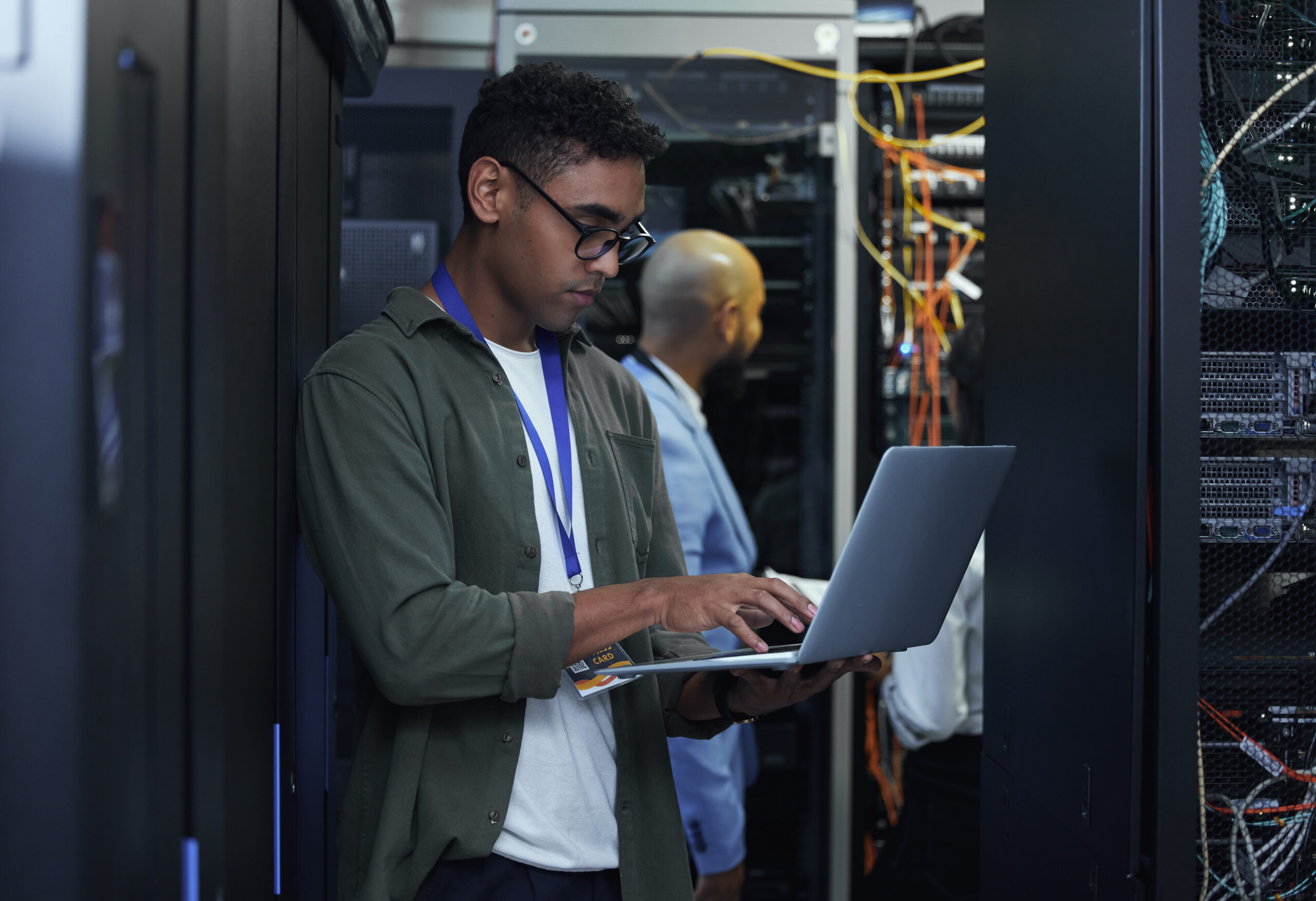 IT work in progress. Cropped shot of two male IT support agents working together in a dark network server room.